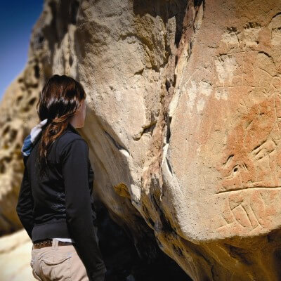 Woman outside looking at petroglyphs